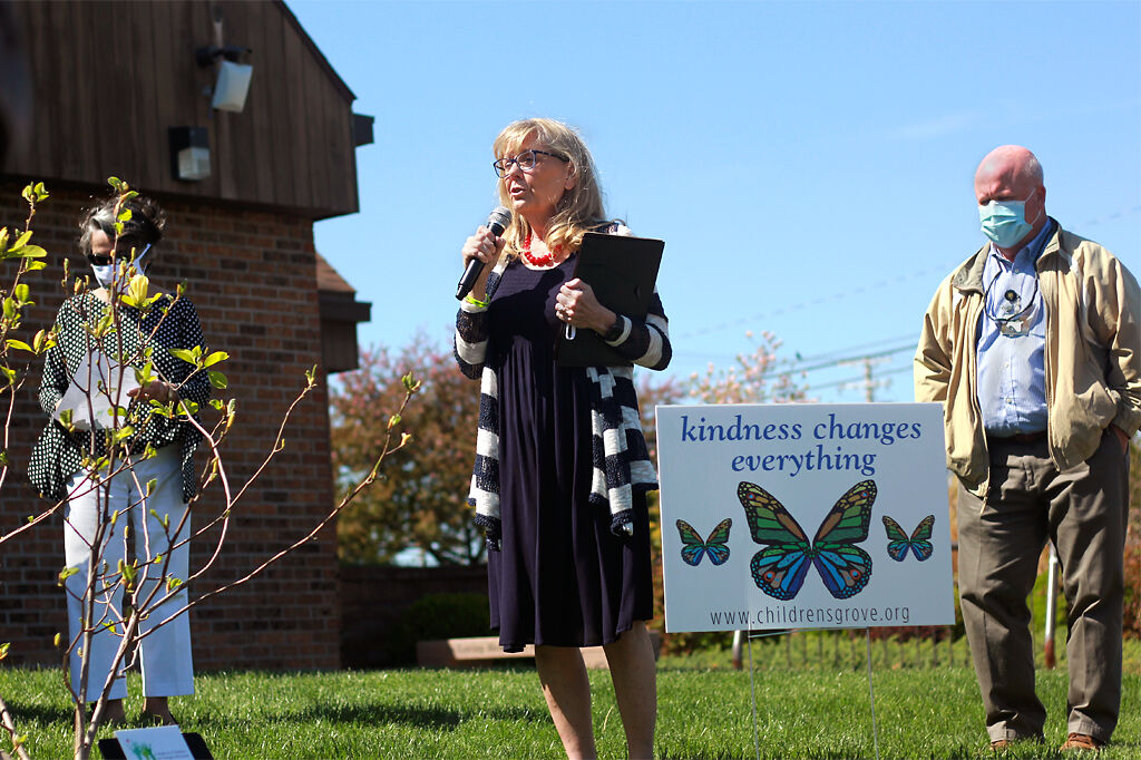 Anne Deaton, Kim Dude-Lammy and Pete Millier open the Children's Grove kindness tree dedication